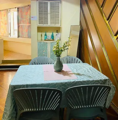 a table with two chairs and a vase with flowers on it at He Condotel Bell in Manila