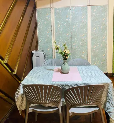 a table with two chairs and a vase with flowers on it at He Condotel Bell in Manila