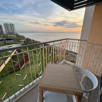 a balcony with a table and a view of the ocean at Panoramic Landscape and Seaview, 2BR, Near Airport, 8m in Manila