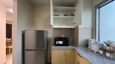 a kitchen with a stainless steel refrigerator and a microwave at Panoramic Landscape and Seaview, 2BR, Near Airport, 8m in Manila