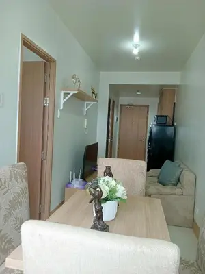 a living room with a table and a couch at Condo Next Door PH in Manila