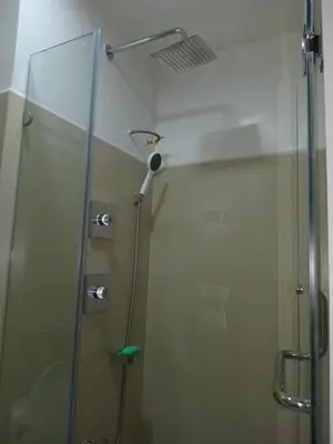 a shower with a glass door in a bathroom at Condo Next Door PH in Manila