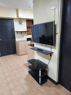 a living room with a flat screen tv on a wall at 2BR Condo near BGC in Manila
