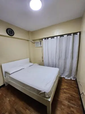 a small bedroom with a bed and a window at 2BR Condo near BGC in Manila