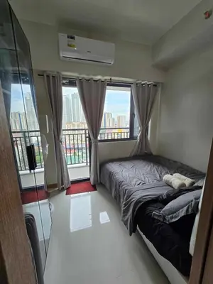a bedroom with a bed with a view of a city at SMDC Red Residences Makati w own parking slot in Manila