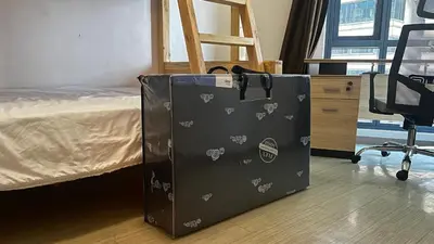 a black bag is sitting next to a bed at 3BR Grand Riviera Suites by MrSayla in Manila