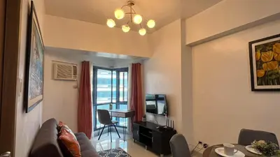 a living room with a couch and a table at 1BR Grand Riviera Suites by MrSayla in Manila