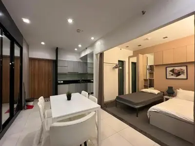a room with a bed and a white table and chairs at 1BR Grand Riviera Suites by MrSayla in Manila