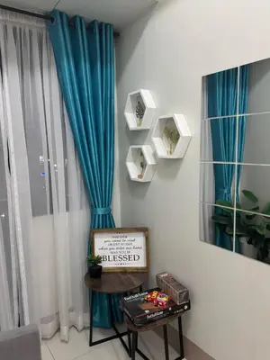 a room with a blue curtain and a table with a sign at Clarquin Residences - Shore 3 Residences Tower 2 in Manila