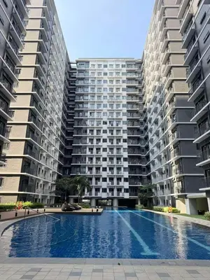 a swimming pool in front of two tall buildings at Clarquin Residences - Shore 3 Residences Tower 2 in Manila