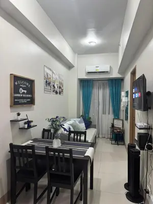 a living room with a table and chairs and a couch at Clarquin Residences - Shore 3 Residences Tower 2 in Manila