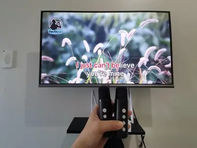 a person holding two video game controllers in front of a tv at Clarquin Residences - Shore 3 Residences Tower 2 in Manila