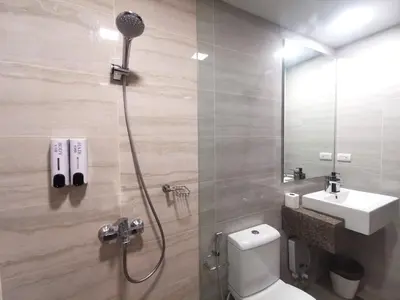 a bathroom with a shower with a toilet and a sink at Bayshore Staycation in Manila