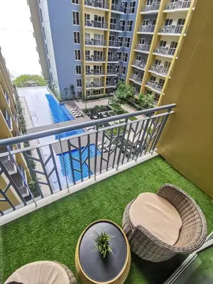 an apartment balcony with a table and chairs at Bayshore Staycation in Manila