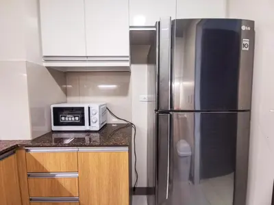 a kitchen with a stainless steel refrigerator and a microwave at Bayshore Staycation in Manila