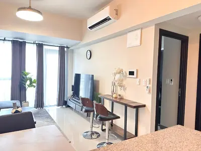 a living room with a television and a table and chairs at Spacious Modern Suites with Amazing City View in Manila