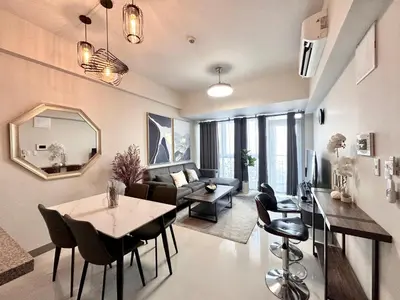 a living room with a table and a couch at Spacious Modern Suites with Amazing City View in Manila