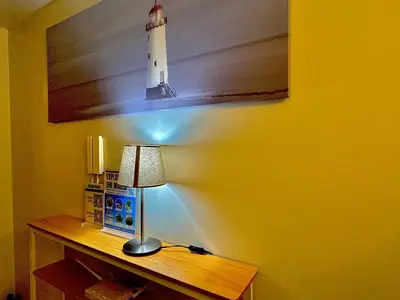 a desk with a lamp and a picture of a lighthouse at Shore 3 Residences - HTZ Haven in Manila