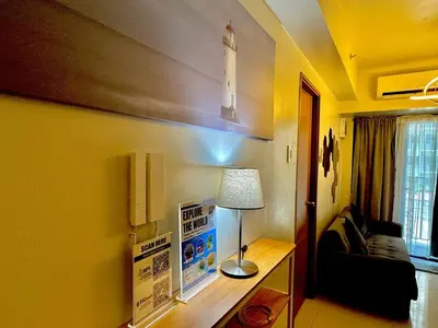 a living room with a lamp and a couch at Shore 3 Residences - HTZ Haven in Manila