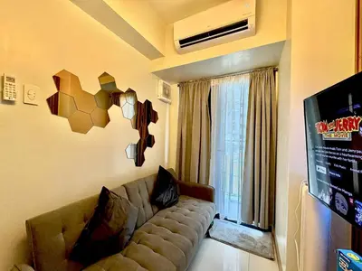 a living room with a couch and a window at Shore 3 Residences - HTZ Haven in Manila