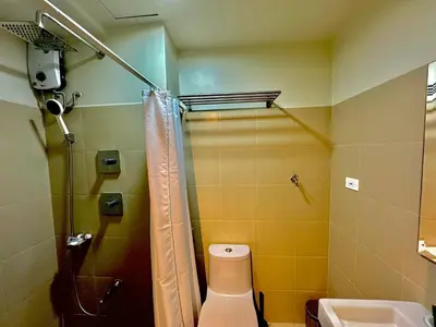 a bathroom with a shower and a toilet and a sink at Shore 3 Residences - HTZ Haven in Manila