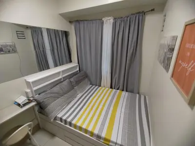 a small bed in a room with a mirror at Shore 3 Residences - HTZ Haven in Manila
