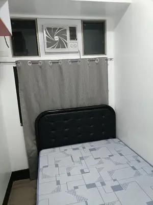 a small bedroom with a bed and a air conditioner at A place to relax & have privacy in Manila