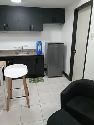 a kitchen with a refrigerator and a table and a chair at A place to relax & have privacy in Manila