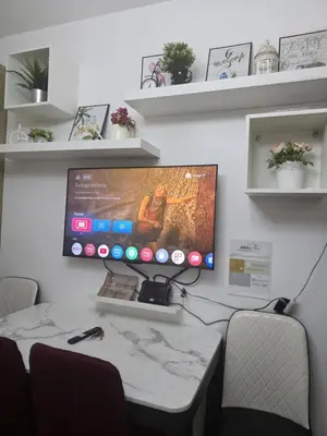 a desk with a computer monitor on a wall at Ethans Place in Manila