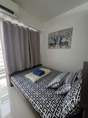 a bedroom with a bed with a black and white comforter at Ethans Place in Manila