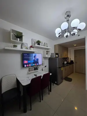 a dining room with a table and a kitchen at Ethans Place in Manila
