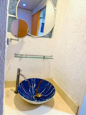 a bathroom with a blue sink and a mirror at He Condotel Blessed in Manila