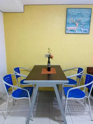 a table with blue chairs and a vase with flowers at He Condotel Blessed in Manila