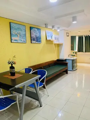 a waiting room with a table and chairs and a sink at He Condotel Blessed in Manila