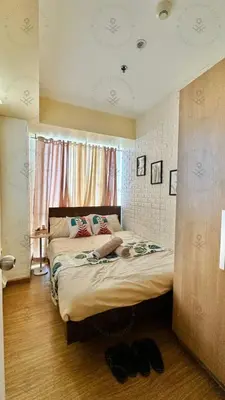 a bedroom with a large bed in a room with a window at 2BR condo Azure Netflix, Karaoke & Board games in Manila