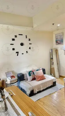 a bedroom with a bed with a clock on the wall at 2BR condo Azure Netflix, Karaoke & Board games in Manila