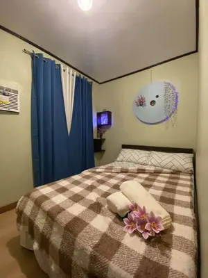 a bedroom with a bed with a checkered blanket at Casa Amaya RNR Transient House in Tanza