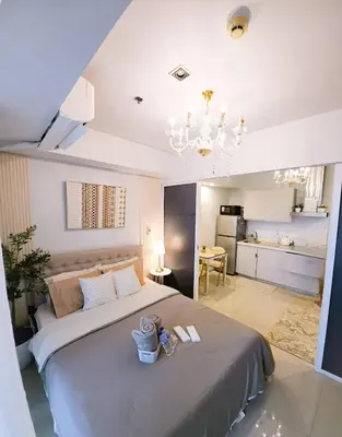 a bedroom with a large bed and a kitchen at Quick Stay PH in Manila