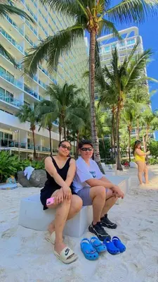 a couple of people sitting on a bench on the beach at Quick Stay PH in Manila