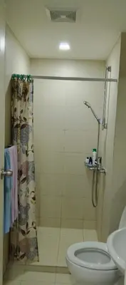 a bathroom with a shower and a toilet and a sink at Quick Stay PH in Manila