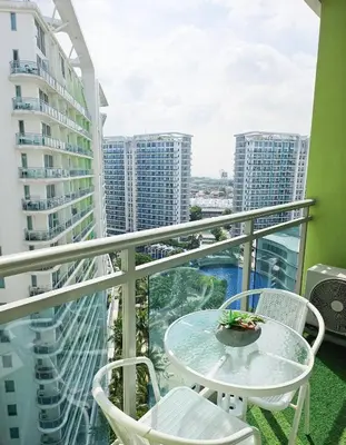 a balcony with a table and chairs and buildings at Quick Stay PH in Manila