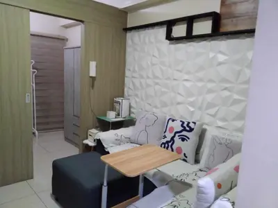 a living room with a couch and a table at Breeze Residences in Manila