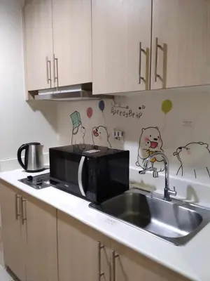 a kitchen with a sink and a microwave at Breeze Residences in Manila