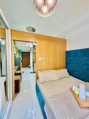 a bedroom with two beds and a chandelier at Deluxe Room Pool View in Mall of Asia Pasay Near Airport in Manila