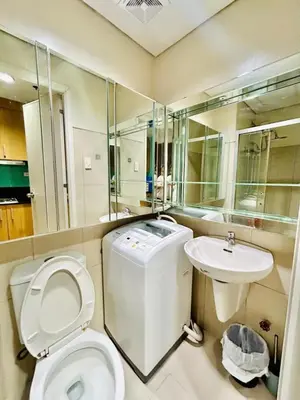 a bathroom with a toilet and a sink at Deluxe Room Pool View in Mall of Asia Pasay Near Airport in Manila