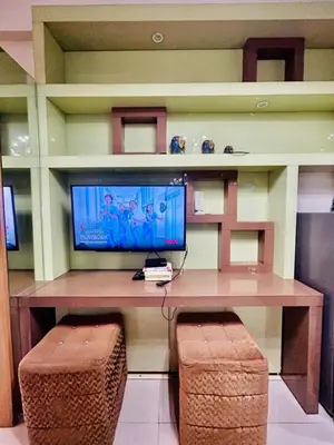 a room with a desk with a tv and two stools at Deluxe Room Pool View in Mall of Asia Pasay Near Airport in Manila
