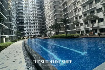 a swimming pool in front of a large apartment building at The Shoreline Suite at Shore 3 Residences MOA Pasay in Manila