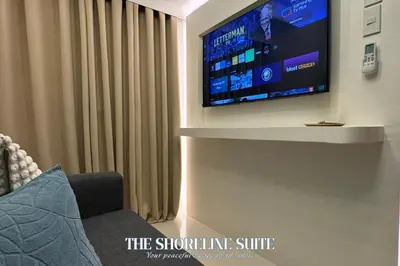 a flat screen tv on a wall in a living room at The Shoreline Suite at Shore 3 Residences MOA Pasay in Manila