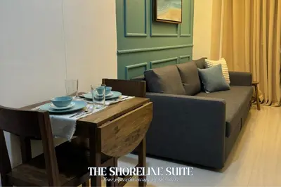 a living room with a couch and a table at The Shoreline Suite at Shore 3 Residences MOA Pasay in Manila
