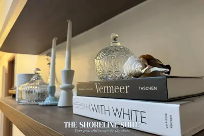 a shelf with two books and a lamp on it at The Shoreline Suite at Shore 3 Residences MOA Pasay in Manila